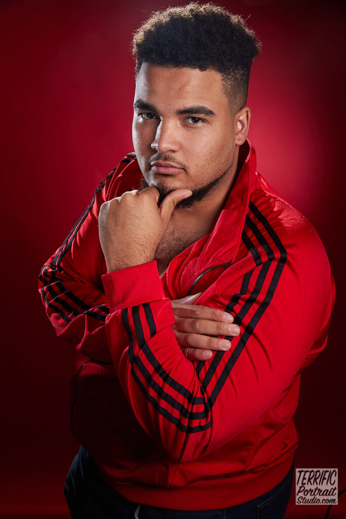 Clifford Michel with arms crossed in a red jacket taken at the Terrific Portrait Studio, Ottawa by Jim Miles